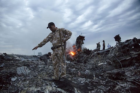 In this July 17, 2014 file photo, people walk amongst the debris at the crash site of a passenger plane near the village of Grabovo, Ukraine. (Photo | AP)