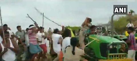 TRS men allegedly beating up forest range officer Anitha (on tractor) in Sirpur, Telangana on Sunday. (Photo | ANI)