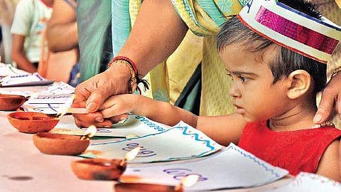 A  newcomer from the welfare council lighting an earthen lamp as part of the Praveshanolsavm at Government Model LPS, Thycaud on Thursday  B P Deepu