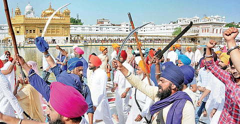 Members of radical Sikh organizations shout slogans and brandish swords during a demonstration on the 34th anniversary of Operation Blue Star on Thursday | PTI