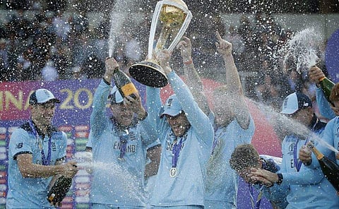 England's captain Eoin Morgan is sprayed with champagne as he raises the trophy after winning the Cricket World Cup final match between England and New Zealand at Lord's cricket ground in London, Sunday, July 14, 2019. England won after a super over after