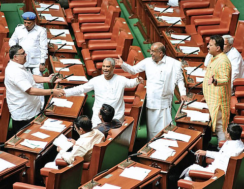 Minister G T Devegowda and Congress MLA Tanveer Sait exchange greetings with BJP MLAs before the Assembly session  at Vidhana Soudha in Bengaluru on Monday (Photo | Vinod Kumar T, EPS)