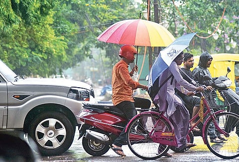 Commuters take cover from rains in Bhubaneswar on Monday  | Express