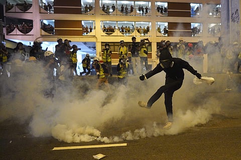 A protestor kicks a tear gas canister during confrontation in Hong Kong Sunday, July 21, 2019. (Photo | AP)