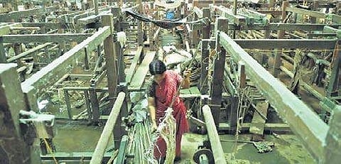 File picture of a worker cleaning a loom at Chendamangalam Albin Mathew