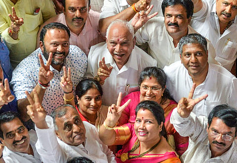 BJP State President BS Yeddyurappa with his party MLAs show victory sign after HD Kumaraswamy lost the vote of confidence during Assembly Session at Vidhana Soudha in Bengaluru Tuesday July 23 2019. | PTI