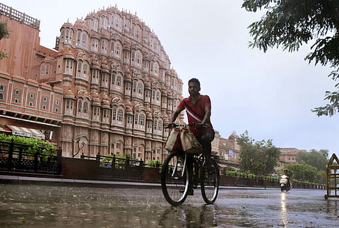A cyclist pedals through rain in the Walled City area of Jaipur Friday July 26 2019. | PTI