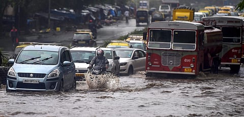 Vehicles wade through a waterlogged road af ter heavy downpour in Mumbai.  (Photo | PTI)