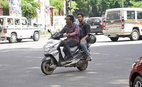 Two men travel on a two-wheeler without wearing helmets. (Photo | B P Deepu, EPS)