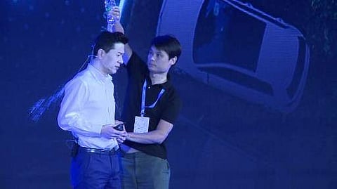 This framegrab taken from AFPTV shows a man (R) pouring water Baidu co-founder and CEO Robin Li during Baidu Create 2019 in Beijing on July 3, 2019.  (Photo | AFP)