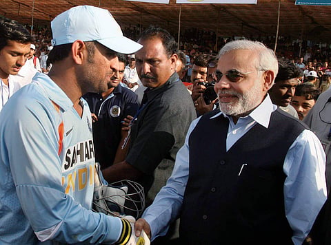 Then Gujarat CM Narendra Modi shakes hands with skipper MS Dhoni as he greets Indian team for their win over England in the first ODI at the Madhavrao Scindia cricket ground. (File Photo | PTI)