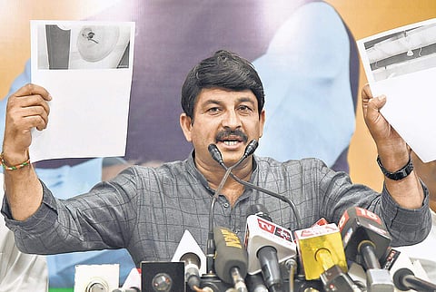 Delhi BJP chief Manoj Tiwari shows documents while addressing a press conference in New Delhi. (Photo | Parveen Negi)