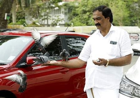 P H Abdul Salam feeding pigeons  near Fort Kochi beach. (Photo | Arun Angela, EPS)
