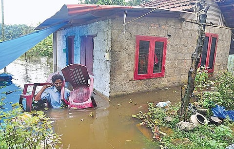 Sivan of Poickattussery near Chengamanad shifting furniture from his inundated house on Friday. | Express Photo Services
