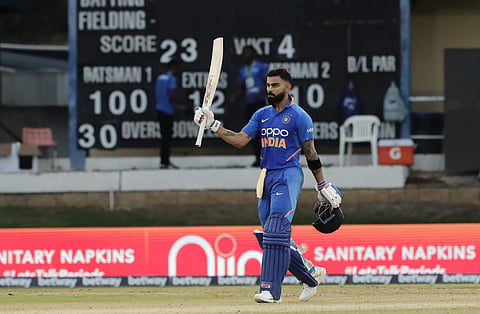 India captain Virat Kohli raises his bats to celebrate reaching a century during the third One-Day International cricket match West Indies in Port of Spain, Trinidad. (Photo | AP)