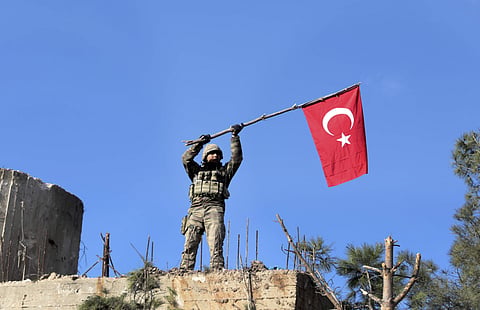 An image of a soldier waving a Turkish flag as Turkish troops secure Bursayah hill, which separates the Kurdish-held enclave of Afrin from the Turkey-controlled town of Azaz. President Recep Tayyip Erdogan has repeatedly claimed that the HDP has ties to t