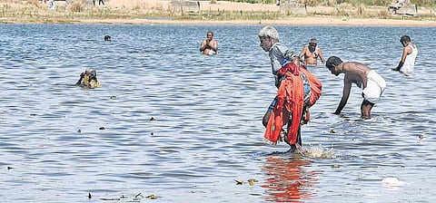 Selvam, a fisherman from Musiri, Tiruchy, collecting clothes left by devotees in the Cauvery river  | M K Ashok Kumar
