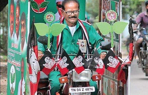 A stauch supporter of AIADMK riding his bike covered with party flags and banners featuring party leaders across the  constituency seeking votes for AC Shamugam | Dinesh S