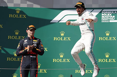Mercedes driver Lewis Hamilton, right, of Britain celebrates on the podium with second placed Red Bull driver Max Verstappen, of the Netherlands, after winning the Hungarian Formula One Grand Prix at the Hungaroring racetrack in Mogyorod, northeast of Bud