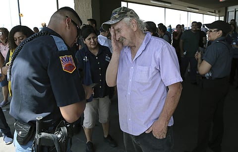 An El Paso Police Officer interviews a witness who was inside the Walmart near the Cielo Vista Mall in Texas, after an active shooter opened fire killing several shoppers.