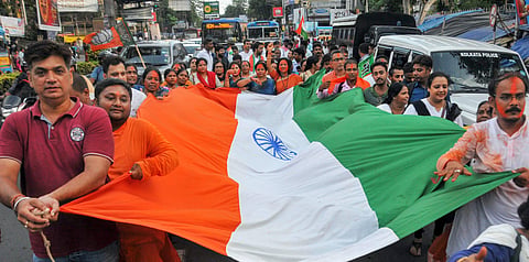 BJP supporters celebrate with a giant National flag te Central government's move to revoke Article 370 in Jammu and Kashmir.  (Photo | PTI)