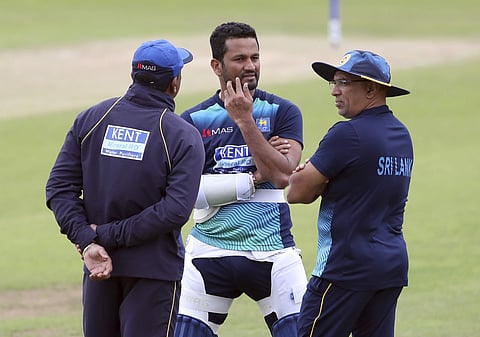 Sri Lanka's captain Dimuth Karunaratne, center, interacts with axed coach Chandika Hathurusingha, right.  | AP
