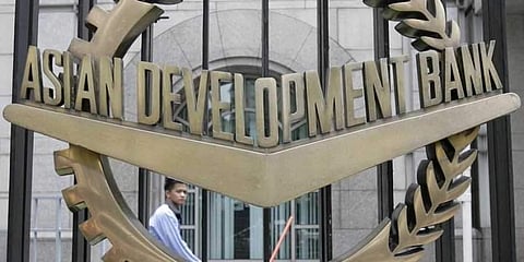 A man walks past the Asian Development Bank (ADB) headquarters in Manila. (File photo | Reuters)