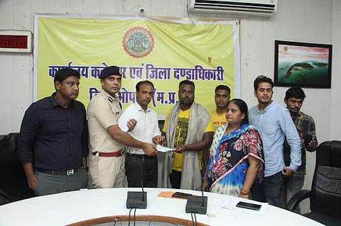 Brave heart swimmer being honoured by  district collector and SP in Bhopal on Saturday. | (Photo | EPS)