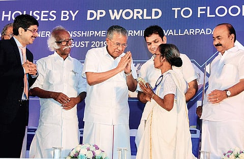 Chief Minister Pinarayi Vijayan greeting Ambujakshi, a beneficiary after  handing over the keys of houses built under ‘Rebuild Kerala’ scheme. Ports Minister Ramachandran Kadannanppally and Hibi Eden MP are also seen (Photo|  EPS, Arun Angela)