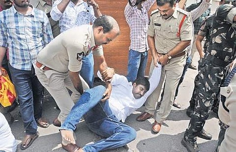 Police arrest TNSF activists while staging a protest against alleged village volunteer recruitment question paper leakage at the APPSC office in Vijayawada on Friday  (Photo| EPS, Prasant Madugula)