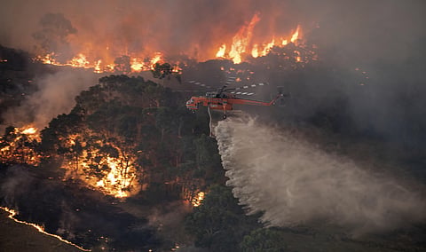 In this Monday, Dec. 30, 2019 photo provided by State Government of Victoria, a helicopter tackles a wildfire in East Gippsland, Victoria state, Australia. (Photo | AP) 