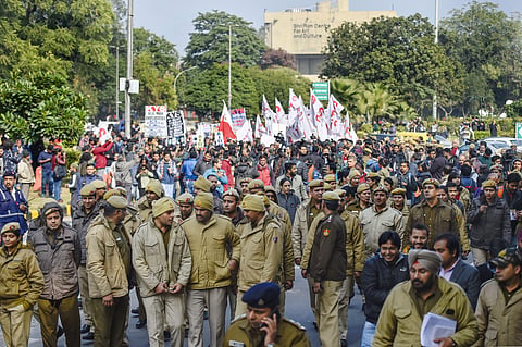 Police personnel walk in front of JNU students' protest march from Mandi House to HRD Ministry demanding removal of the university vice-chancellor at Ferozeshah Road in New Delhi Thursday Jan. 9 2020. (Photo | PTI)