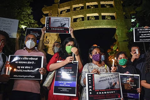 AISF activists hold placards and light candles demanding justice for the Hathras gang-rape victim. (Photo | PTI)