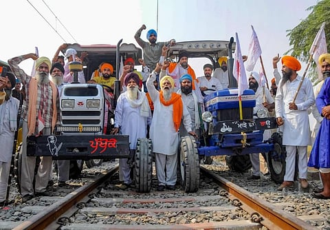 Farmers raise slogans as they block train tracks with tractors on the twentieth day of their ongoing 'Rail Roko' protest over recent farm reform bills. (Photo | PTI)