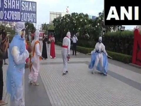 A group of students of fashion designing in Surat perform 'Garba' sporting hand-painted costumes made of PPE kits. (Photo | ANI)