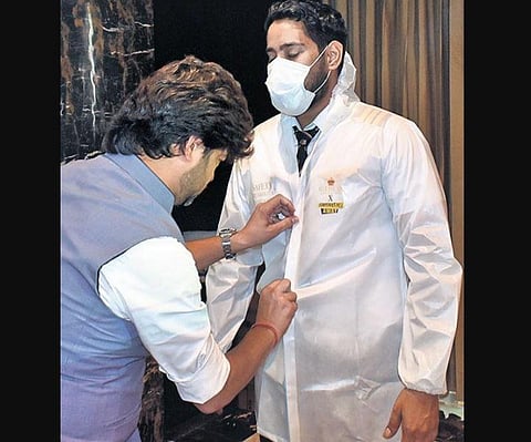 Manish Tripathi puts the Covid Coat on a model at the launch.