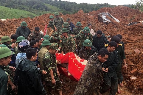 Military personnel carrying a body recovered from the site of a landslide in central Vietnam's Quang Tri. (Photo| AFP)