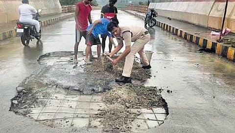 Kothavalasa constable with the help of three youths fixing potholes on China Ravupalli bridge in Vizianagaram I express