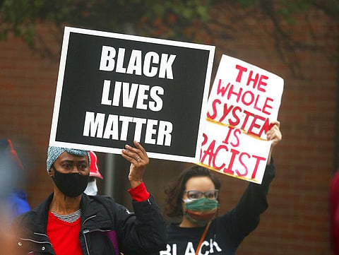 People hold signs during a protest rally for Marcellis Stinnette who was killed by Waukegan Police last Tuesday in Waukegan, Ill., Thursday, Oct. 22, 2020. (Photo | AP)