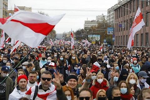 People with old Belarusian national flags march during an opposition rally to protest the official presidential election results in Minsk, Belarus, Sunday, Oct. 25. (Photo | AP)