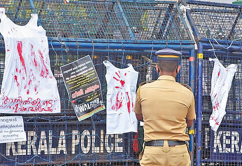 A policeman looks at the petticoats hung on a barricade in front of the Secretariat by Yuva Morcha and Youth Congress supporters, in a symbolic protest demanding justice for the two minor sisters who