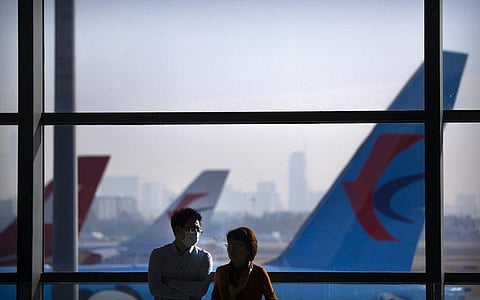 A traveler wearing a face mask to protect against the coronavirus stands at a boarding gate at the Shanghai Hongqiao International Airport. (Photo | AP)