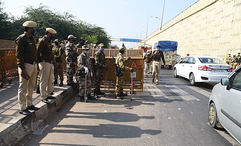 Police personnel check vehicles at Delhi UP border ahead of the scheduled farmers protest march to Delhi.