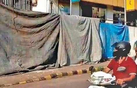Police cover the graffiti to avoid any untoward incident, in Mangaluru on Friday