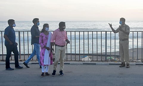 Police official tries to disperse the crowd gathered at Shanghumugham beach in Thiruvananthapuram (File Photo | BP Deepu, EPS)