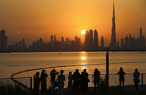 In this Oct. 7, 2016 file photo, people watch the sunset over the skyline, with Burj Khalifa at right, in Dubai. (Photo | AP)