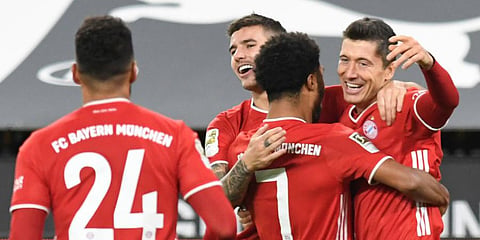Bayern Munich striker Robert Lewandowski (R) celebrates after scoring his side's second goal during the German Bundesliga match against Borussia Dortmund. (Photo | AP)