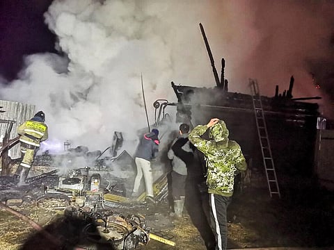 Firefighters work at the site of fire in a retirement home in Ishbuldino village. (Photo| AP)