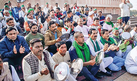 Farmers bang plates during a protest against the new farm laws at Rashtriya Dalit Prerna Sthal in Noida. (Photo | PTI)