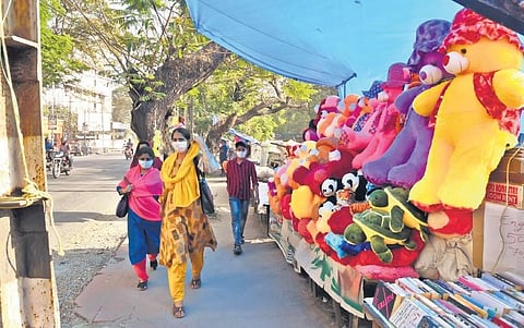 Pedestrians walking past a street shop set up on the footpath near Park Avenue Road